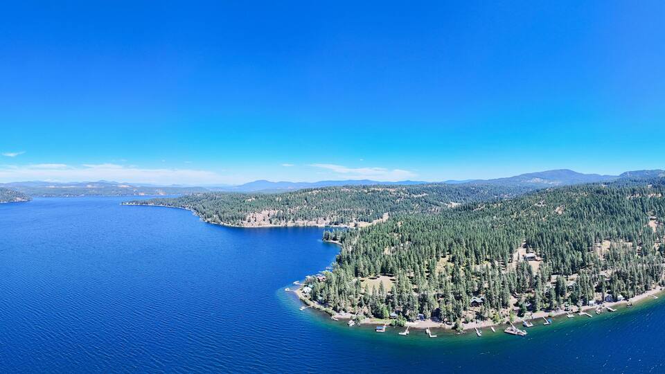 A large body of water surrounded by forested hills and mountains.