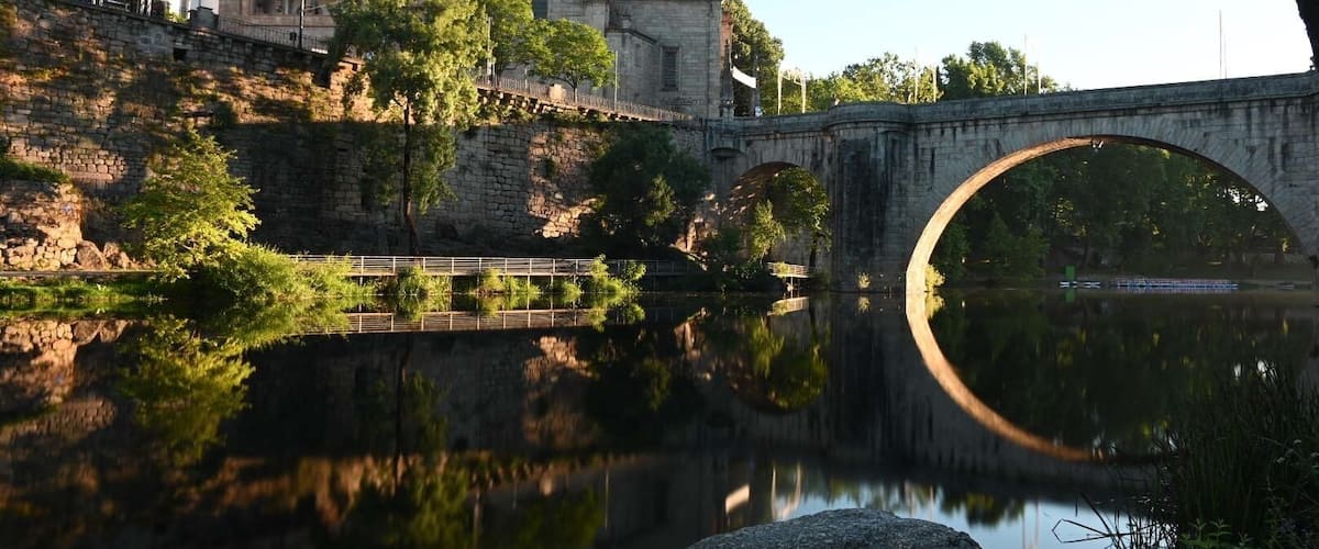 Fun shot at sunrise of Church São Gonçalo and Ponte de São Gonçalo bridge reflecting in Tamega River