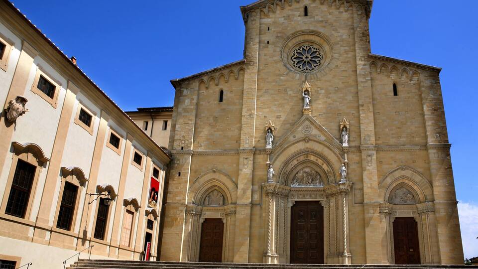 A historic church with a prominent rose window and a bell tower.