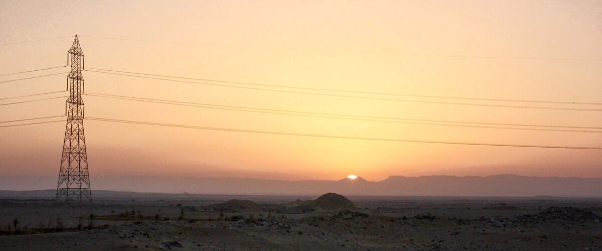 A power tower in a desert landscape at sunset.