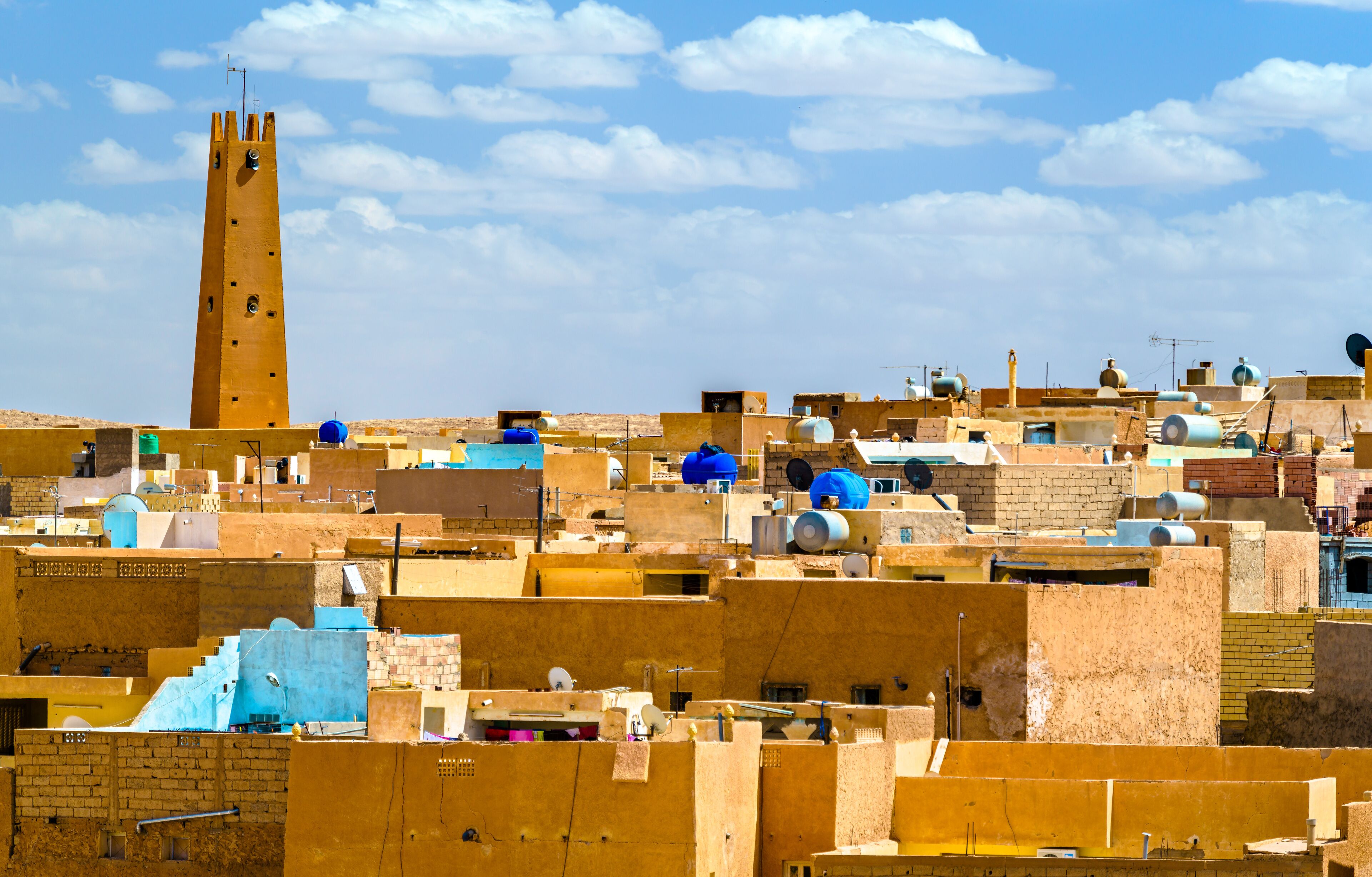 A densely packed urban area with a prominent tower and numerous water tanks.