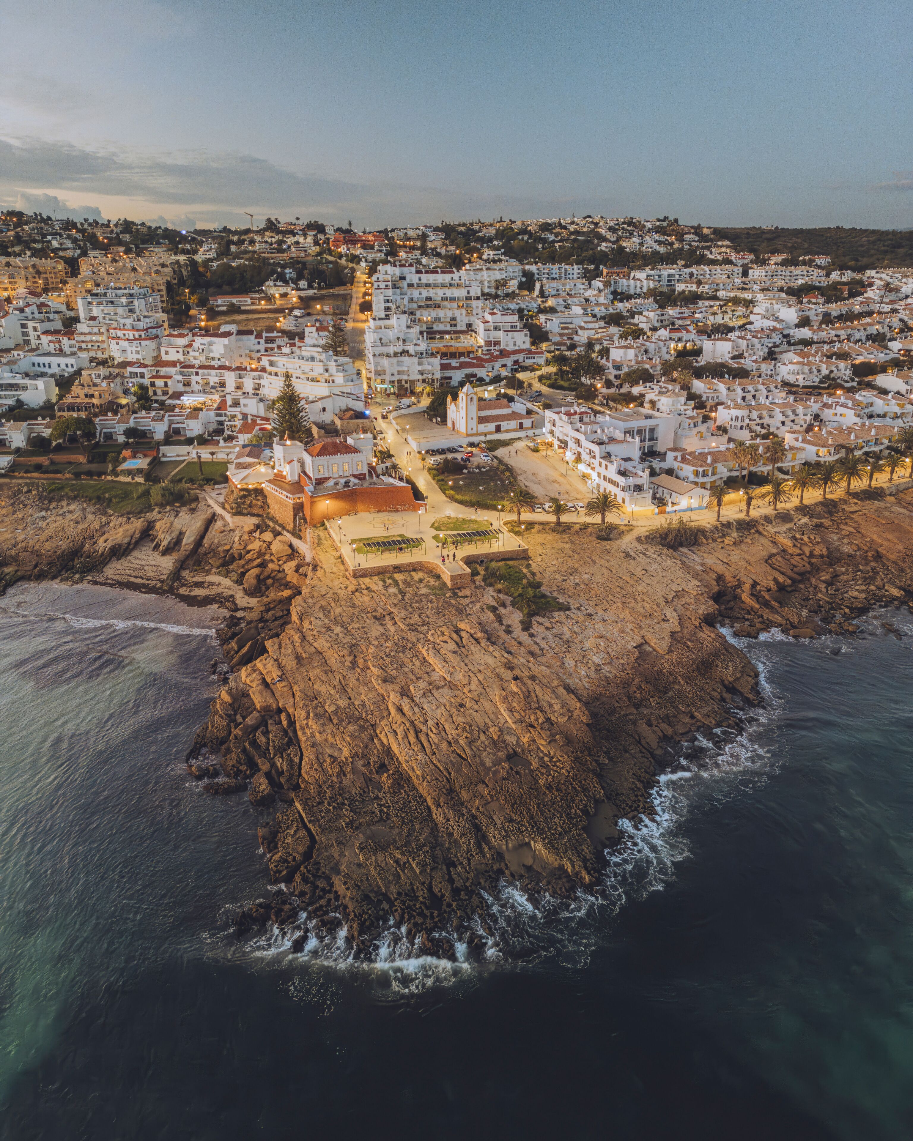 Aerial view of beautiful Praia da Luz with white washed houses and Fortaleza da Luz on the cliff by the ocean, Luz, Portugal.