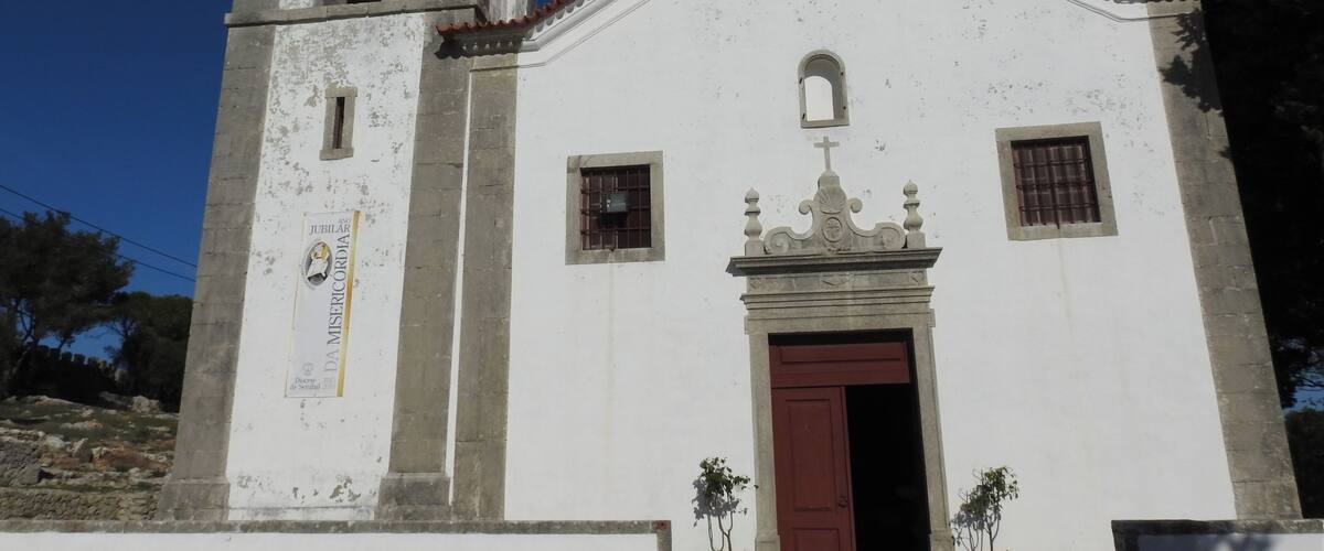 A white church with a bell tower and a red door.