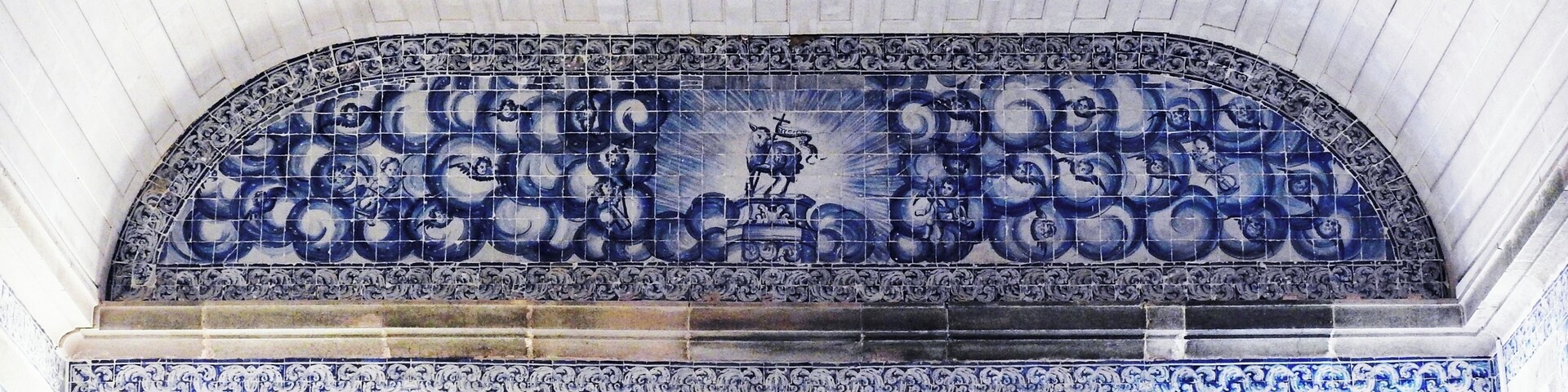 Pared detallada con baldosas azules y blancas y diseños intrincados, con una figura central.