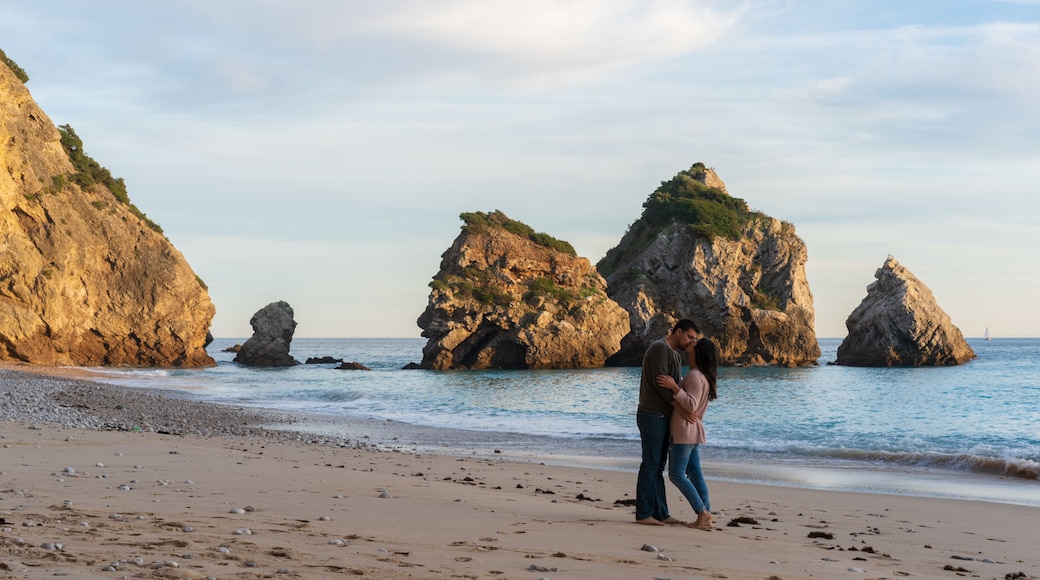Couple kissing on a wild empty beach in Ribeiro do Cavalo, Arrabida, Portugal