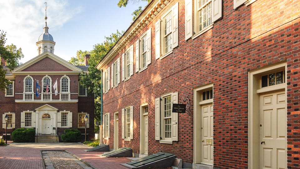 A historic brick building with a white facade and a dome structure.