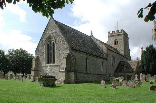 A church with a prominent steeple and a graveyard in the foreground.