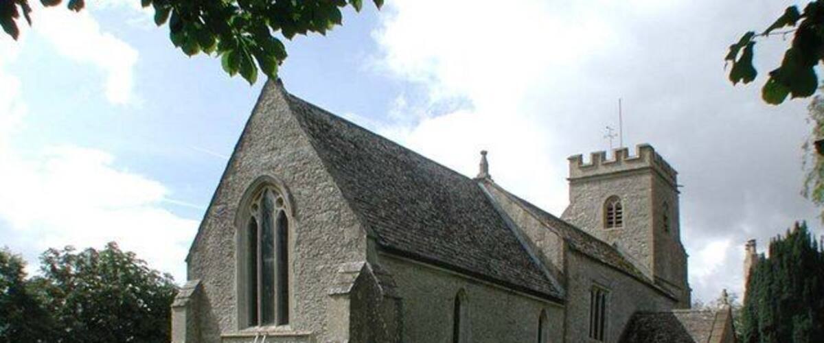 A church with a prominent steeple and a graveyard in the foreground.