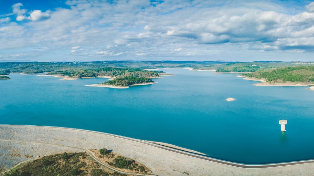A large body of water surrounded by islands and a curved road.