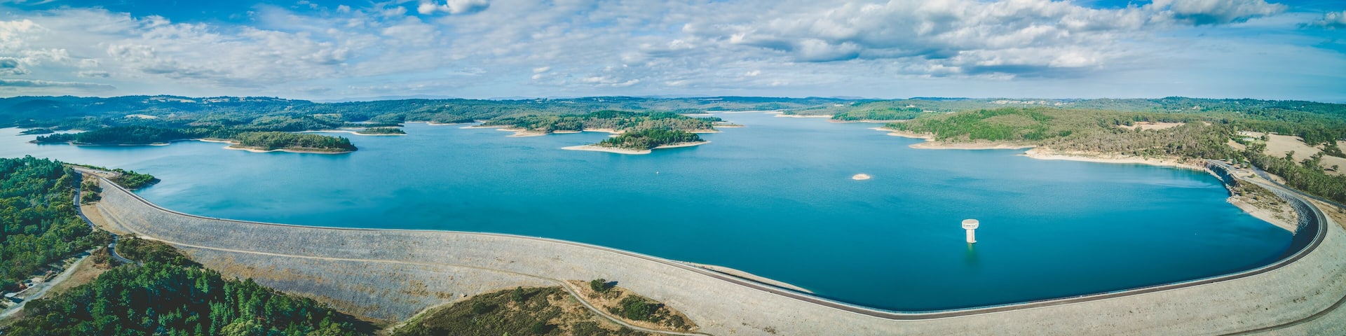 A large body of water surrounded by islands and a curved road.