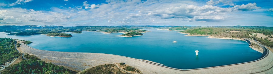 Uma vasta extensão de água cercada por ilhas e uma estrada sinuosa.