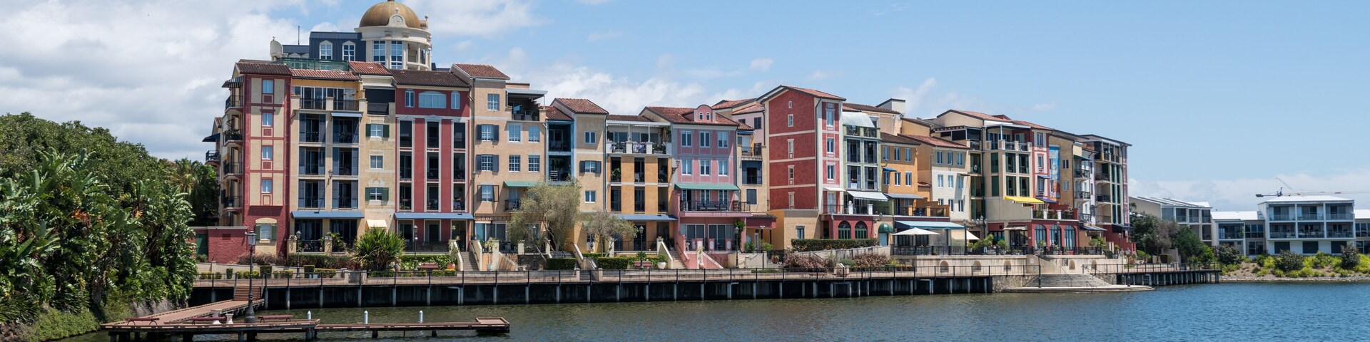 Complejo de edificios frente al agua, con una cúpula destacada y fachadas coloridas.