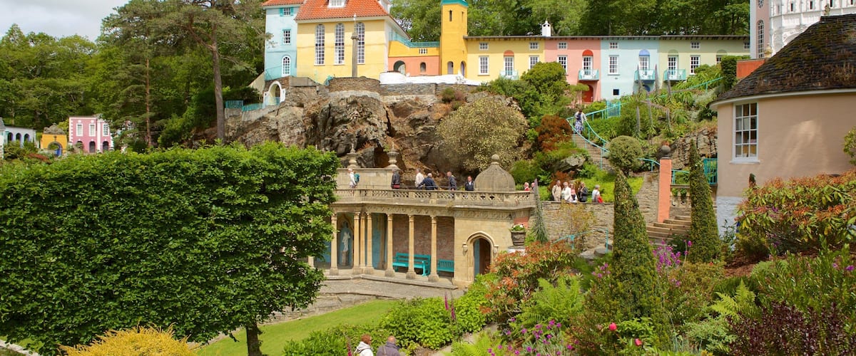 A colorful building with a red roof, a green tower, and a statue in front.