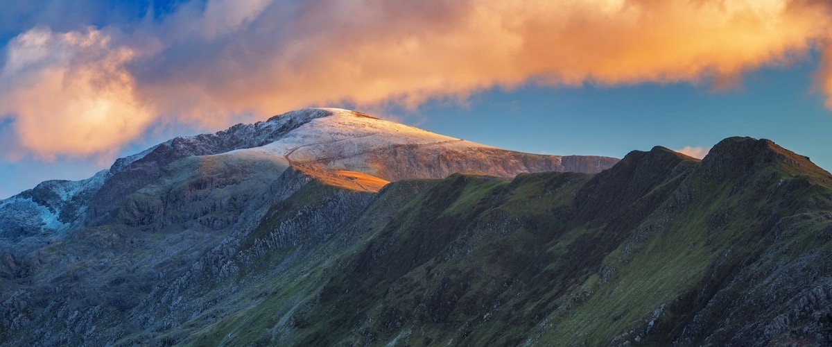 A mountain range with snow-capped peaks and a clear sky.