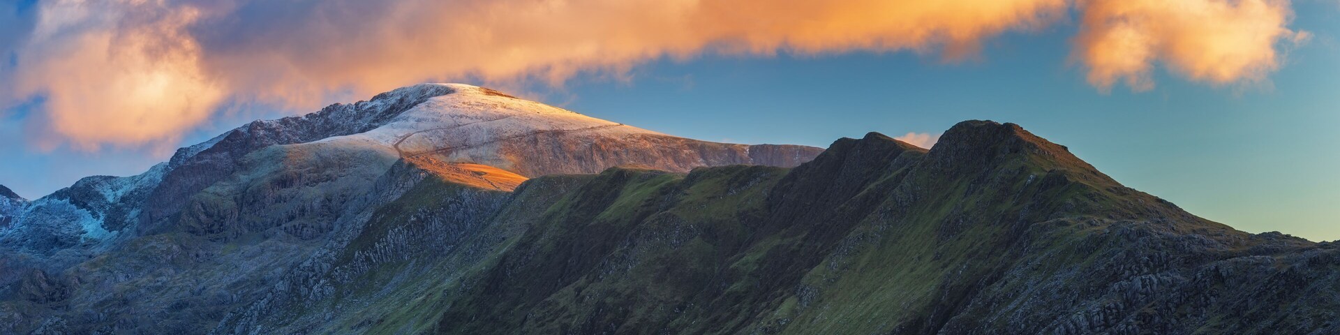 A mountain range with snow-capped peaks and a clear sky.