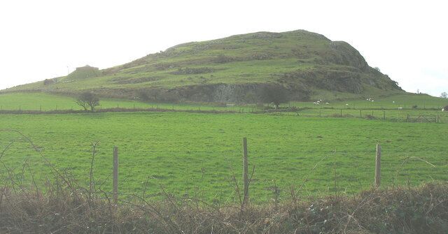 Ein grünes Feld mit einer Hügelkulisse.