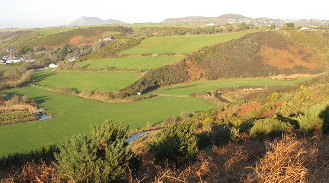 Rolling hills, a small stream, and a distant village.