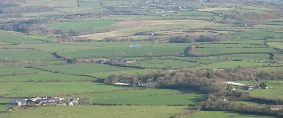 Faerdre Farm and Plas Gelliwig from Rhiw Mountain Faerdre Farm is on the left of the photo. The Caravan parks at Gelliwig form a prominent feature of the landscape as do the kettle lakes.