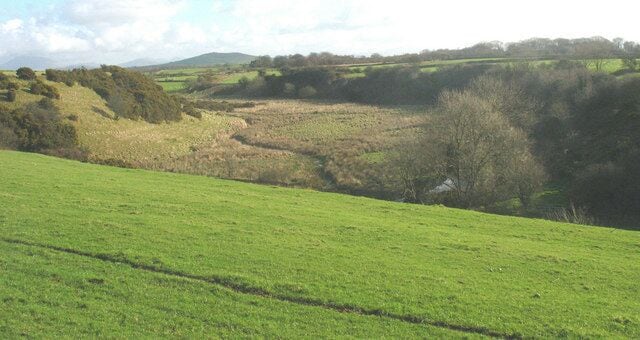 View across the Erch valley from Carnguwch church The Erch meanders over its boggy flood plain. The land use contrasts with that on the terraces above.