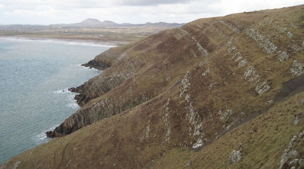 Looking across Trwyn Carreg-y-tir From Trwyn y Fulfran. Coastal erosion has exposed the rock strata which must have helped the lead mining activity around here. A trail of mine waste is visible on the lower right.