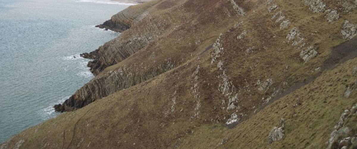 A coastal landscape with rocky cliffs and a body of water.