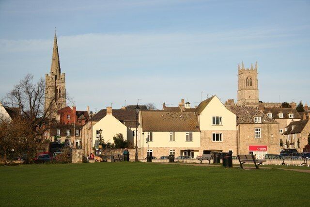 A town with historic buildings, a church spire, and a clock tower.
