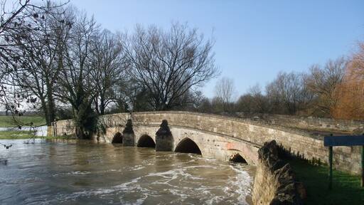 A swollen River Welland passing beneath the old bridge in Duddington