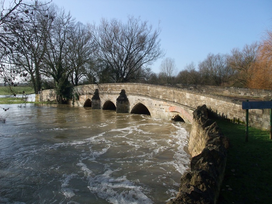 A swollen River Welland passing beneath the old bridge in Duddington