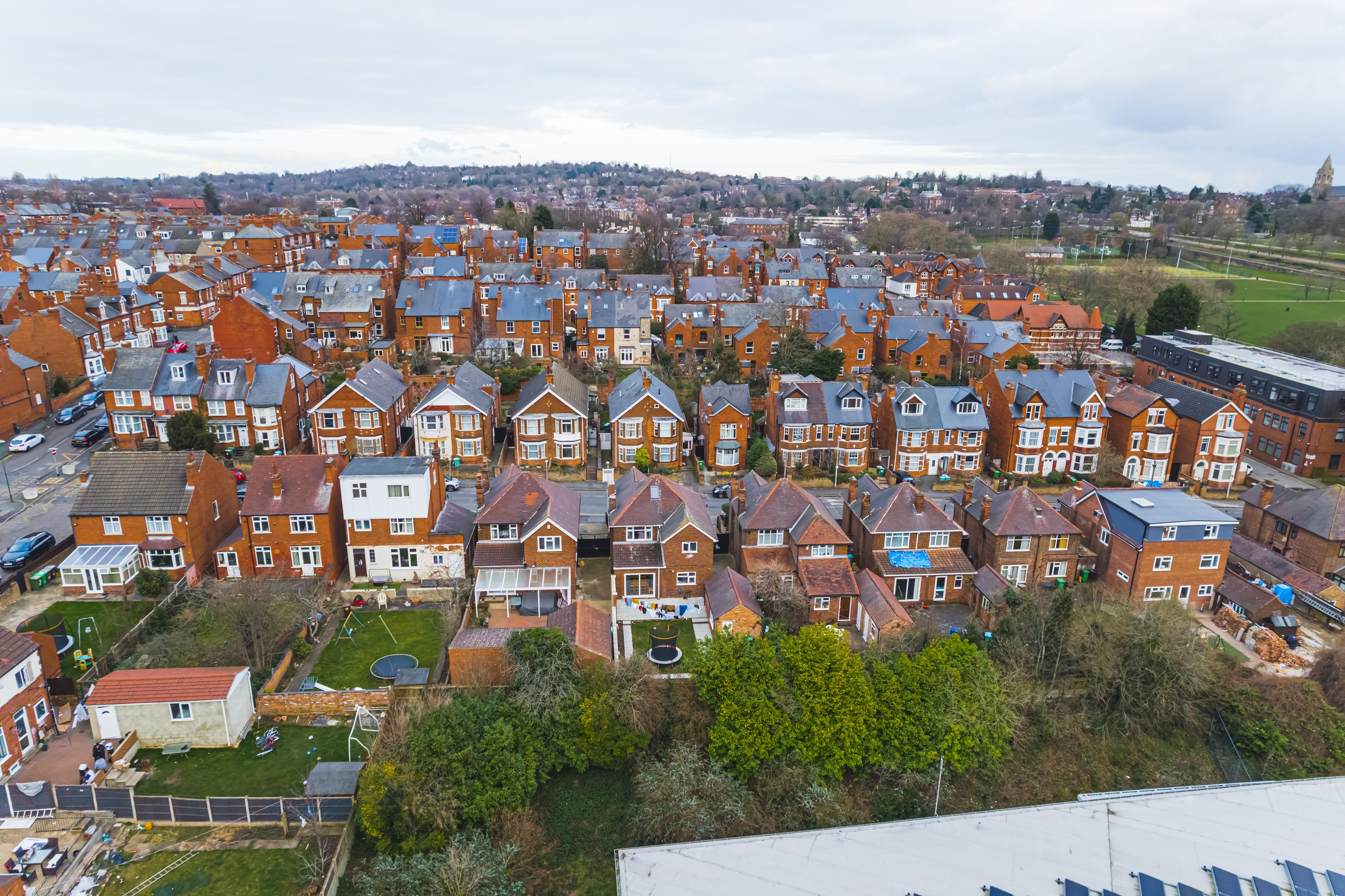A residential area with terraced houses, a park, and a distant church spire.