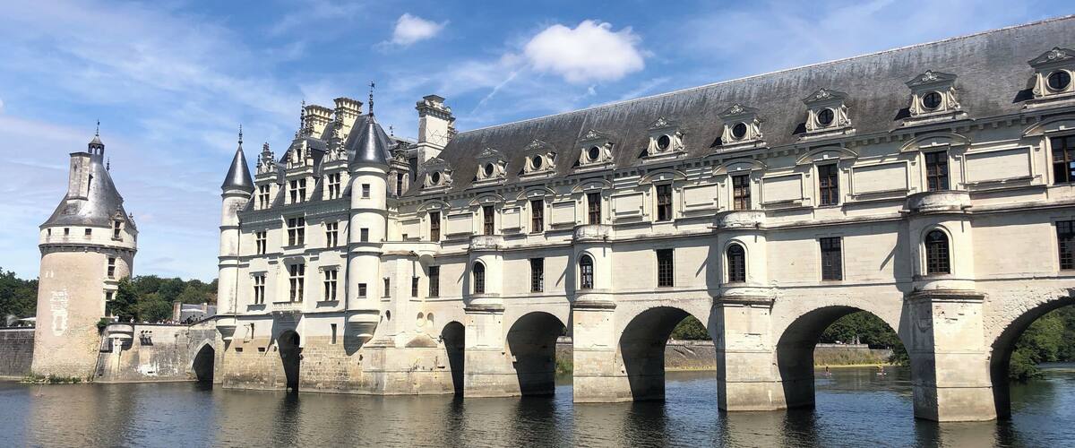 A historic building with a large arched bridge over a river.