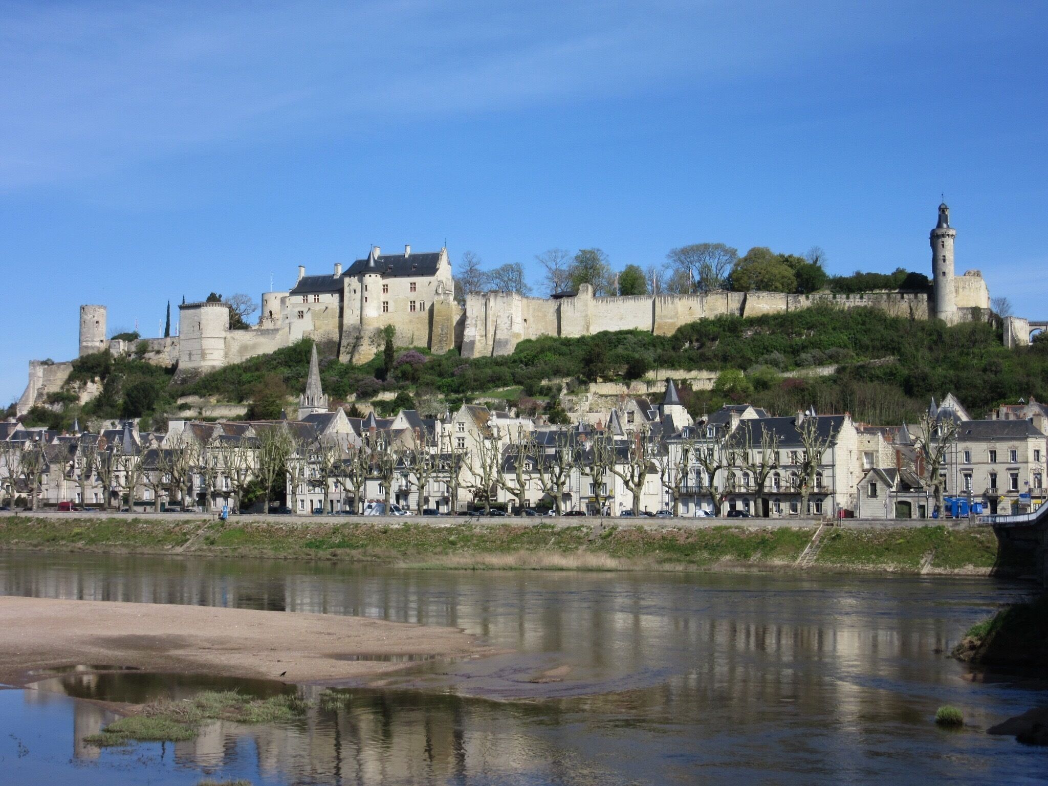 A historic castle on a hill overlooking a river.