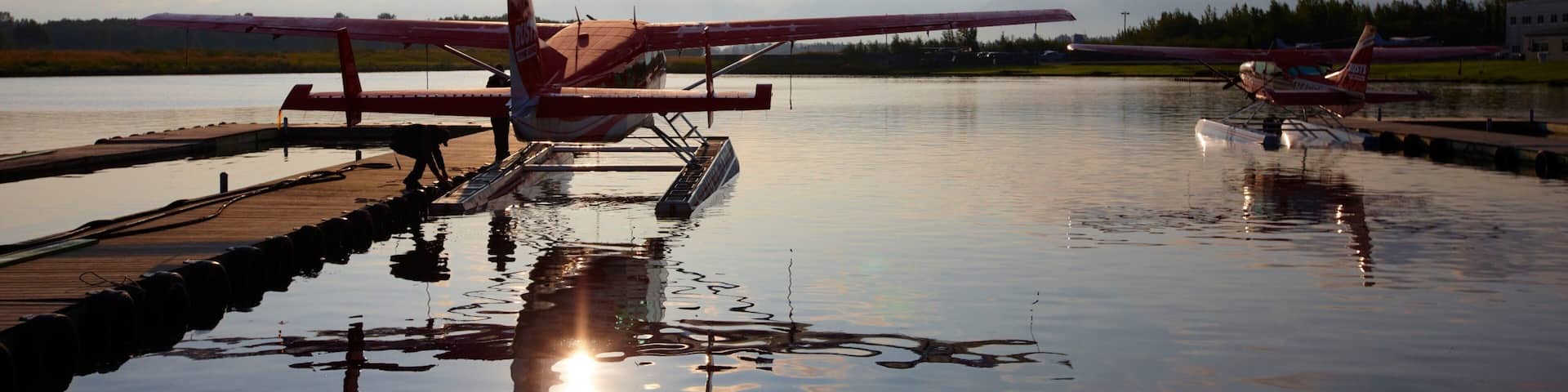Kenai which includes aircraft, a bay or harbor and a sunset
