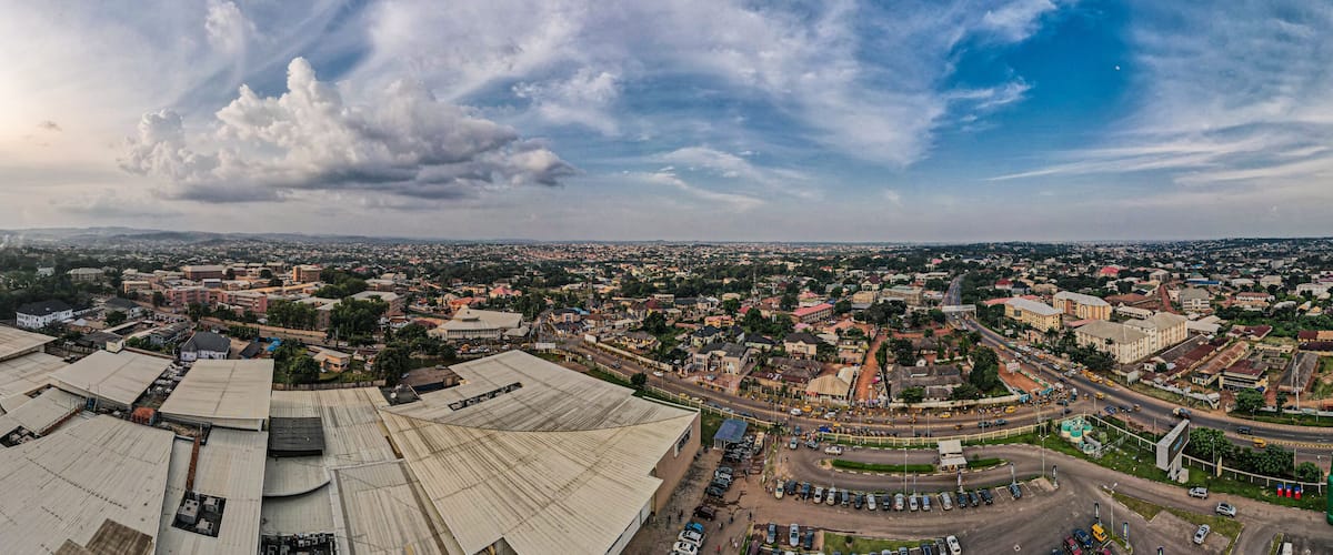 A cityscape with a large industrial area in the foreground and a densely populated urban area in the background.
