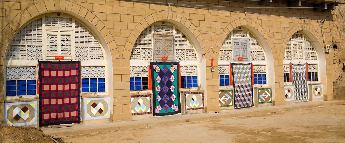A building with arched windows and colorful door decorations.