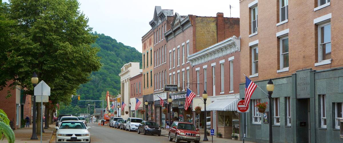 A street lined with historic buildings, American flags, and a First National Bank.