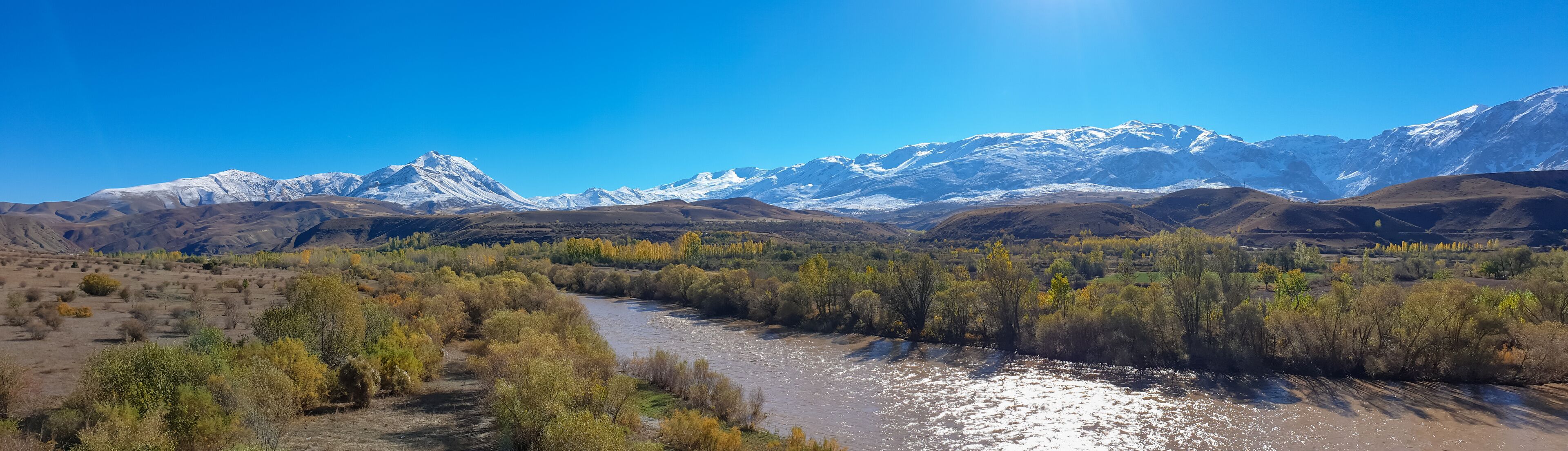 Panoramic view of a valley with snow capped mountains and River Euphrates near Erzincan, Turkey