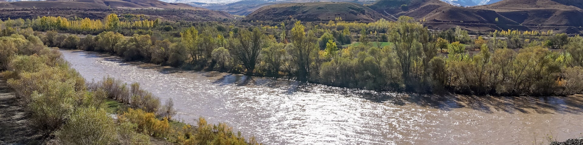 Panoramic view of a valley with snow capped mountains and River Euphrates near Erzincan, Turkey