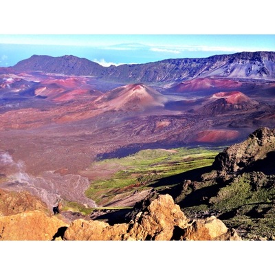 Un paysage volcanique caractérisé par un relief accidenté, des vallées verdoyantes et des collines aux teintes rouge-brun.