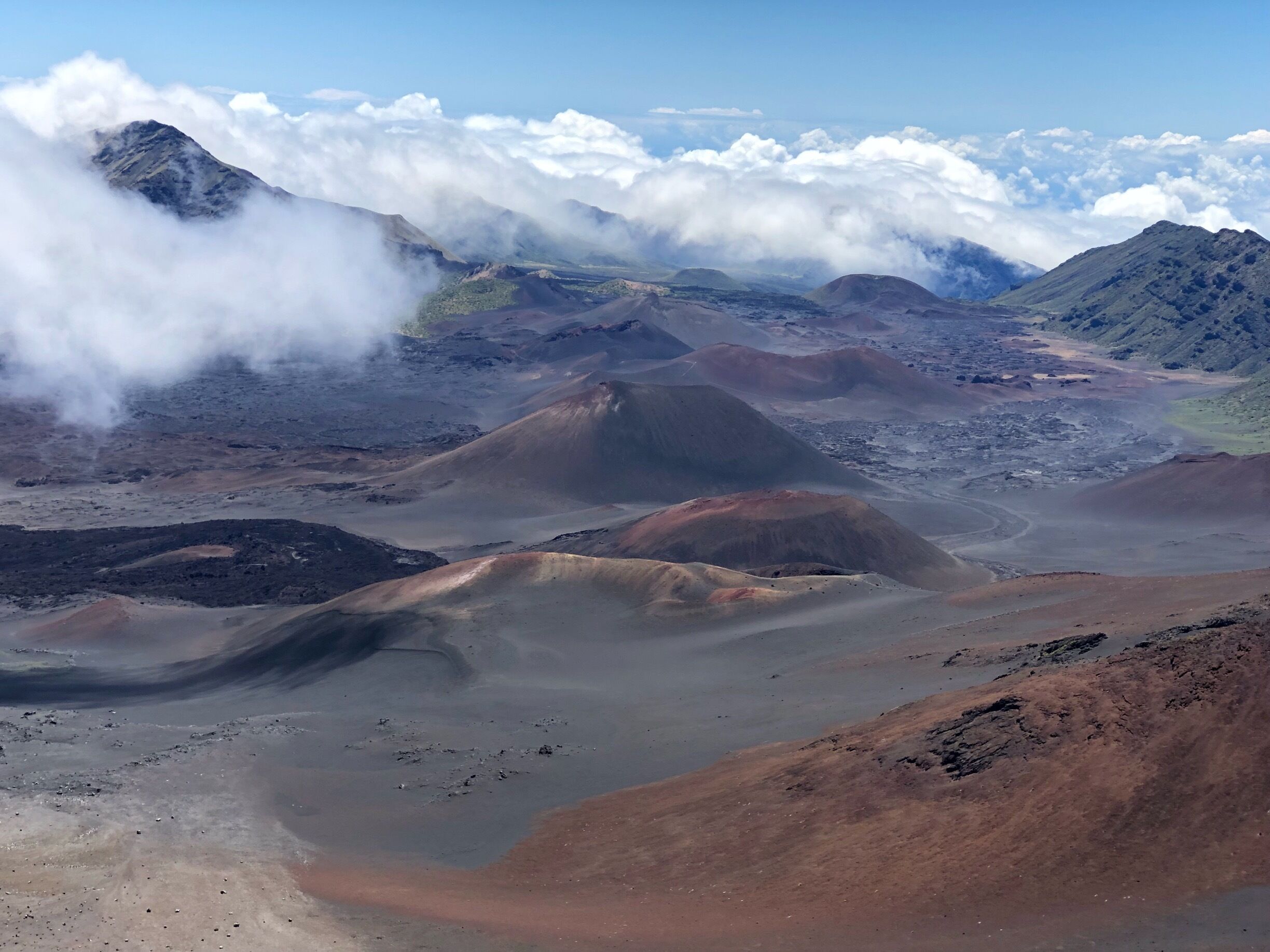 A volcanic landscape with rugged terrain and clouds above.