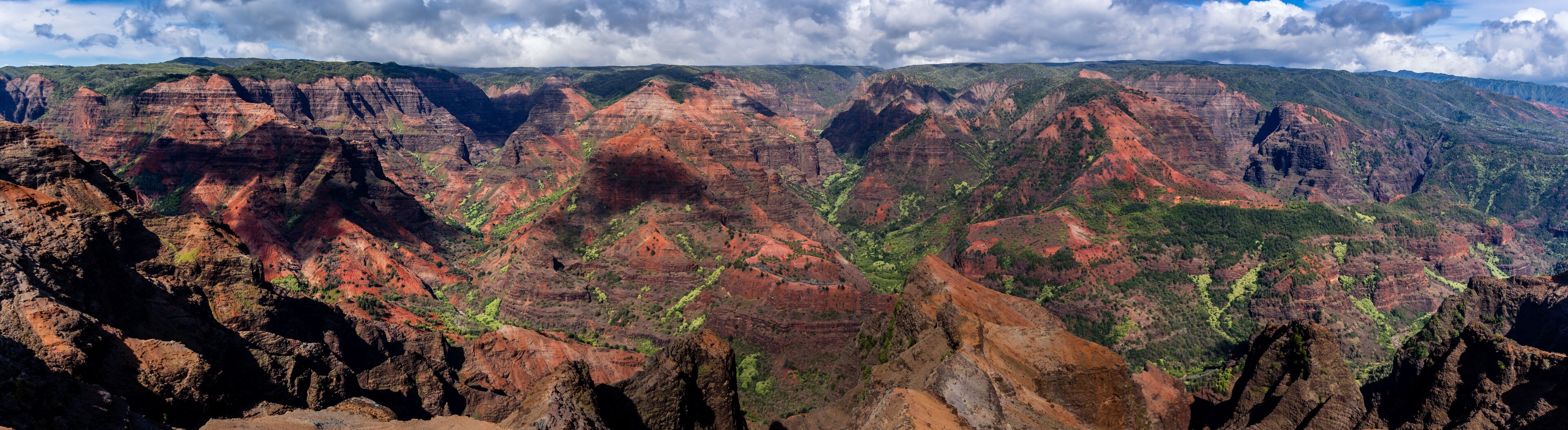 A canyon with layered red and green rock formations.