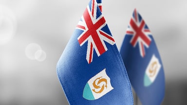 Small national flags of the Anguilla on a light blurry background