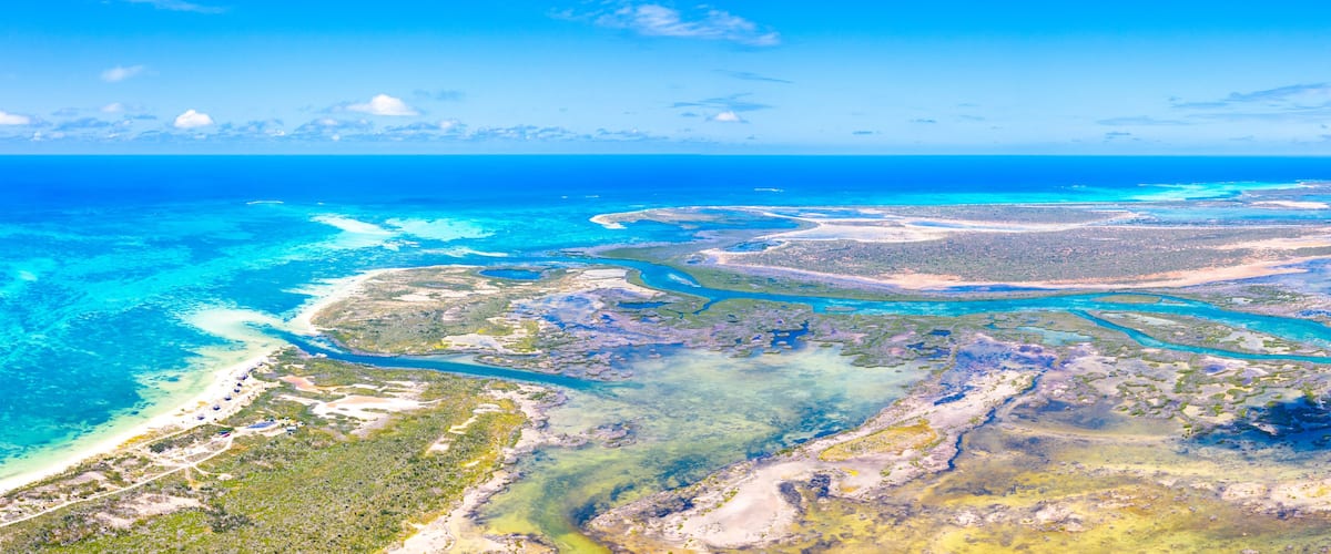 Un paysage côtier caractérisé par des eaux bleues et limpides, des plages de sable et un réseau de voies navigables.