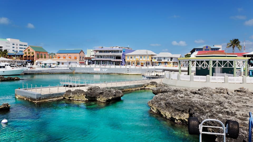 A coastal town with a marina, colorful buildings, and clear turquoise waters.