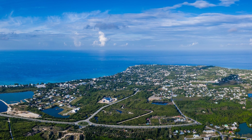 aerial drone footage of the island of grand cayman in the cayman islands in the clear blue and green tropical waters of the caribbean sea