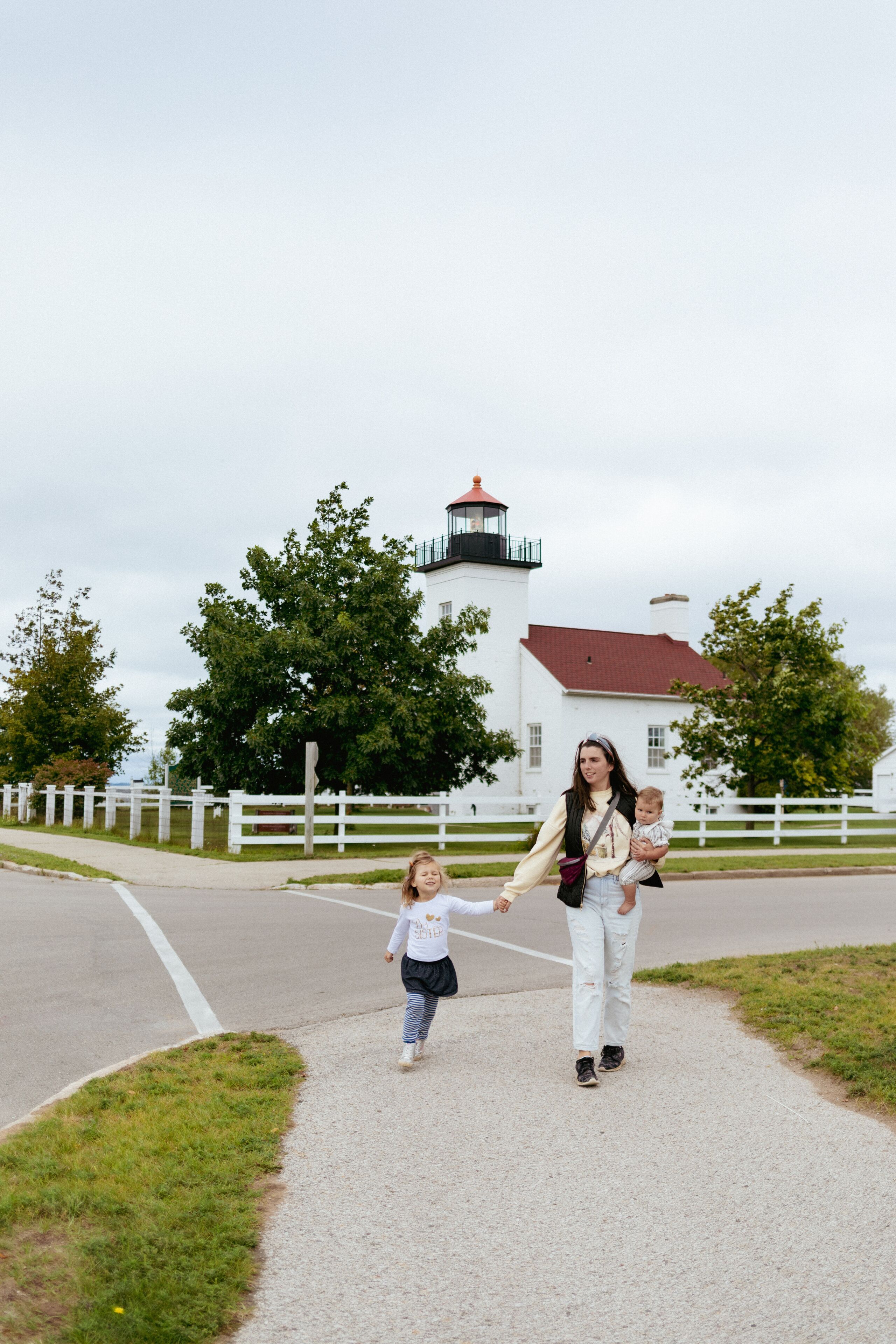 Mother walking with daughters at vacation with lighthouse