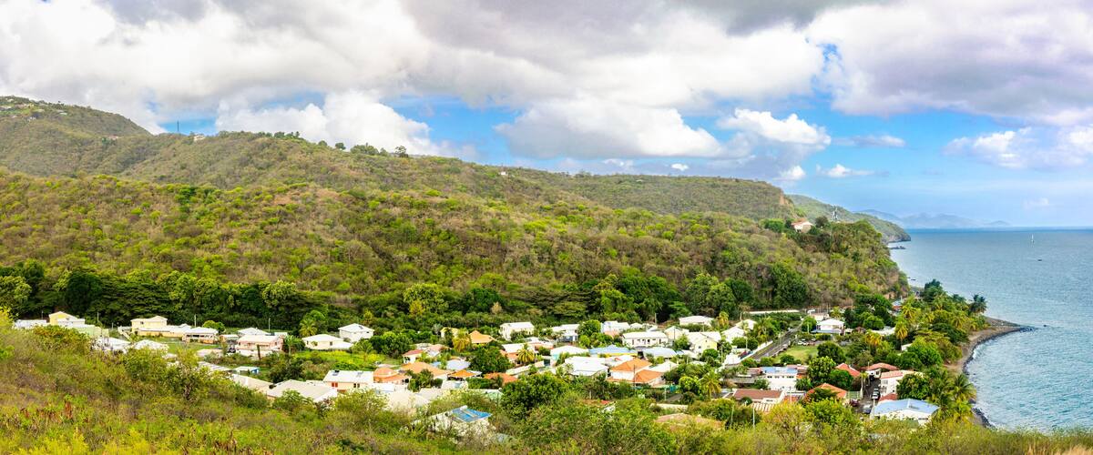 A coastal village with houses nestled on a hillside, overlooking the sea.