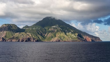 Una isla montañosa con una costa escarpada y edificios dispersos.