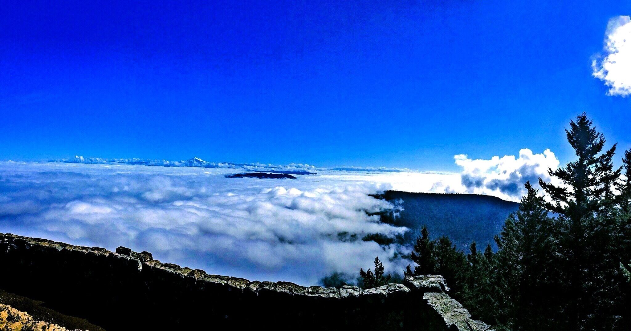 The view from the summit of Mount Constitution is spectacular, even when Rosario Strait and the surrounding bays are socked in with clouds.  Mind you, these are the puffy Reddi Whip kind of clouds, and it is an otherwise beautiful autumn day, but this gives you an idea of what you have in store after a moderate 4.3-mile hike.  There is also a road that will take you right to the top, or give you the option to park at several trailheads closer to the summit.

As for this photograph, if you squint very hard (or resort to a monocle) you can see Mount Baker in the distance.