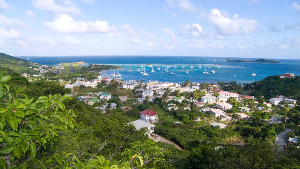 A coastal town with houses, boats, and a clear blue sky.