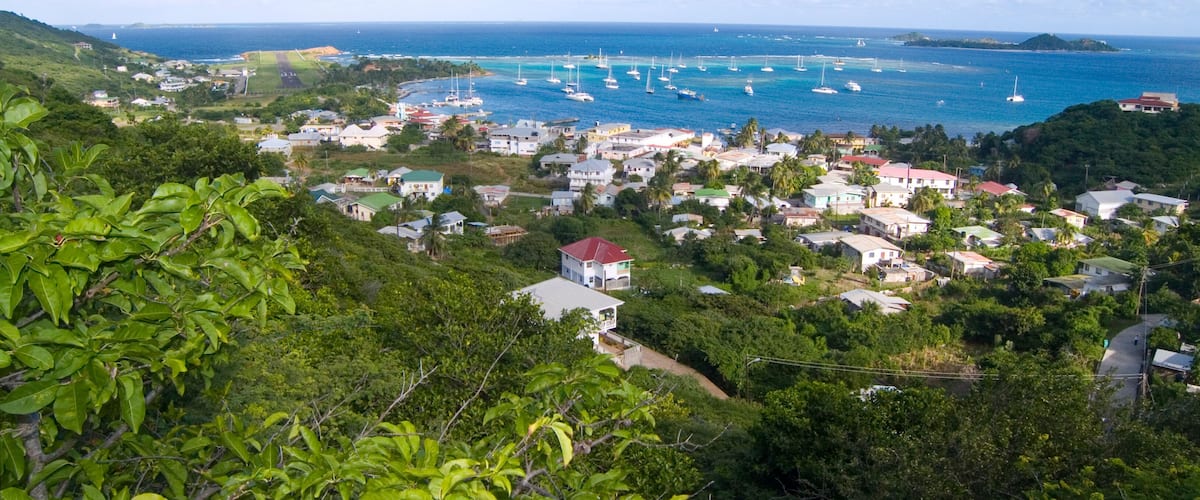 A coastal town with houses, boats, and a clear blue sky.